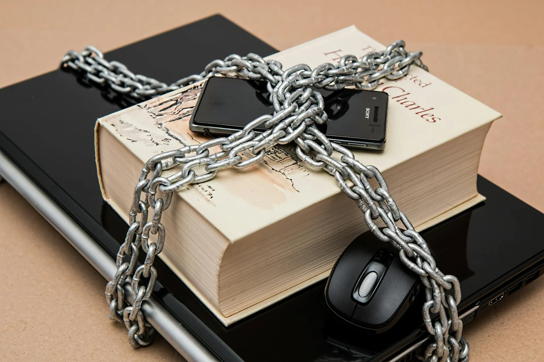 A laptop and book secured with a chain, representing data security and privacy protection for client financial information