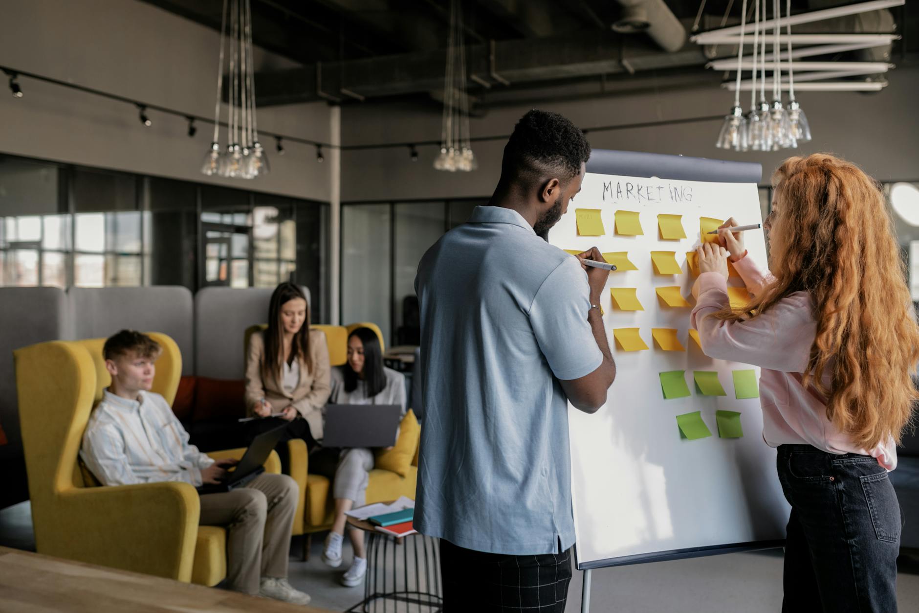 Team collaborating around a planning board in an office, representing a structured workflow and review process for database migrations