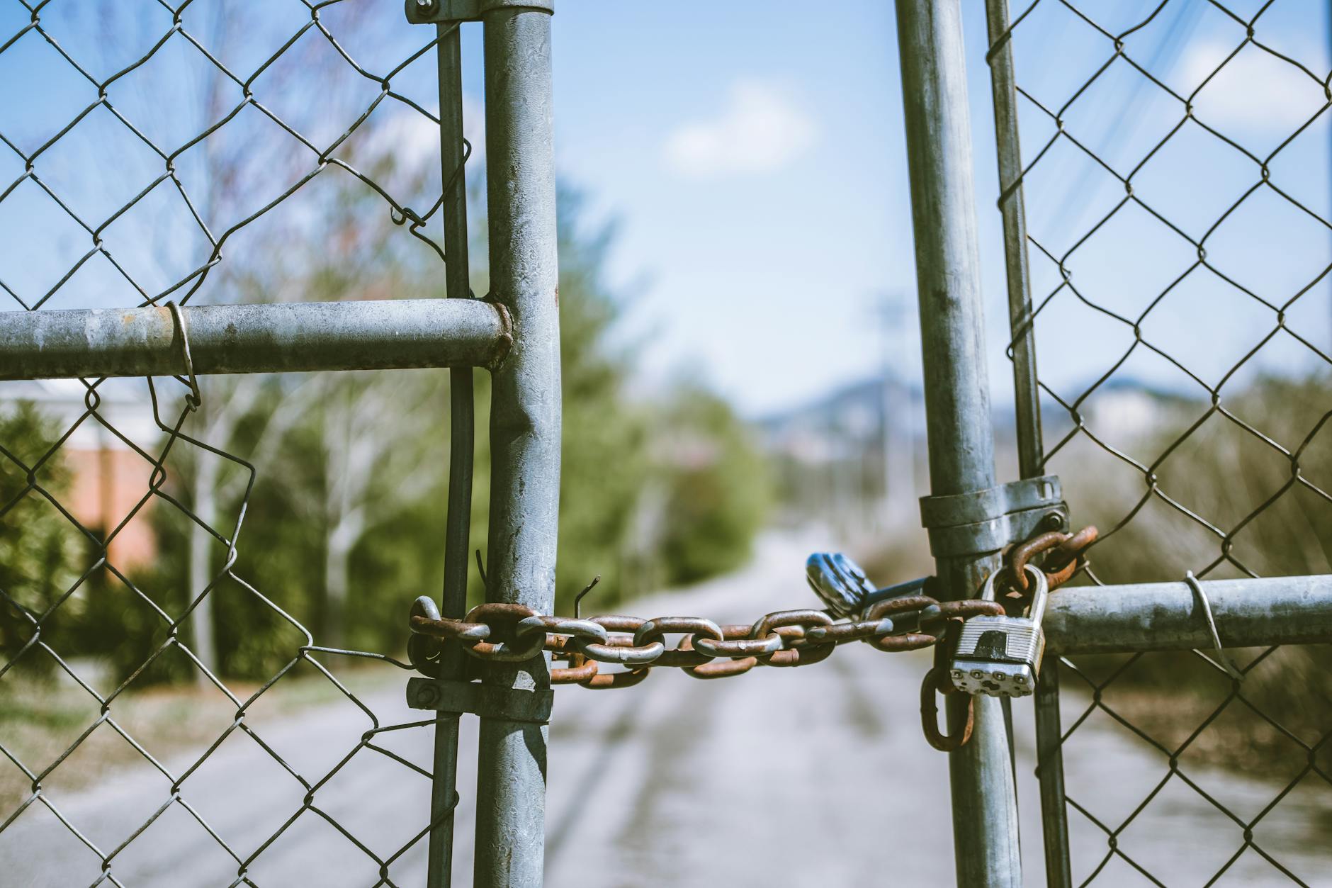 A padlocked chain-link gate representing a security barrier that has been bypassed