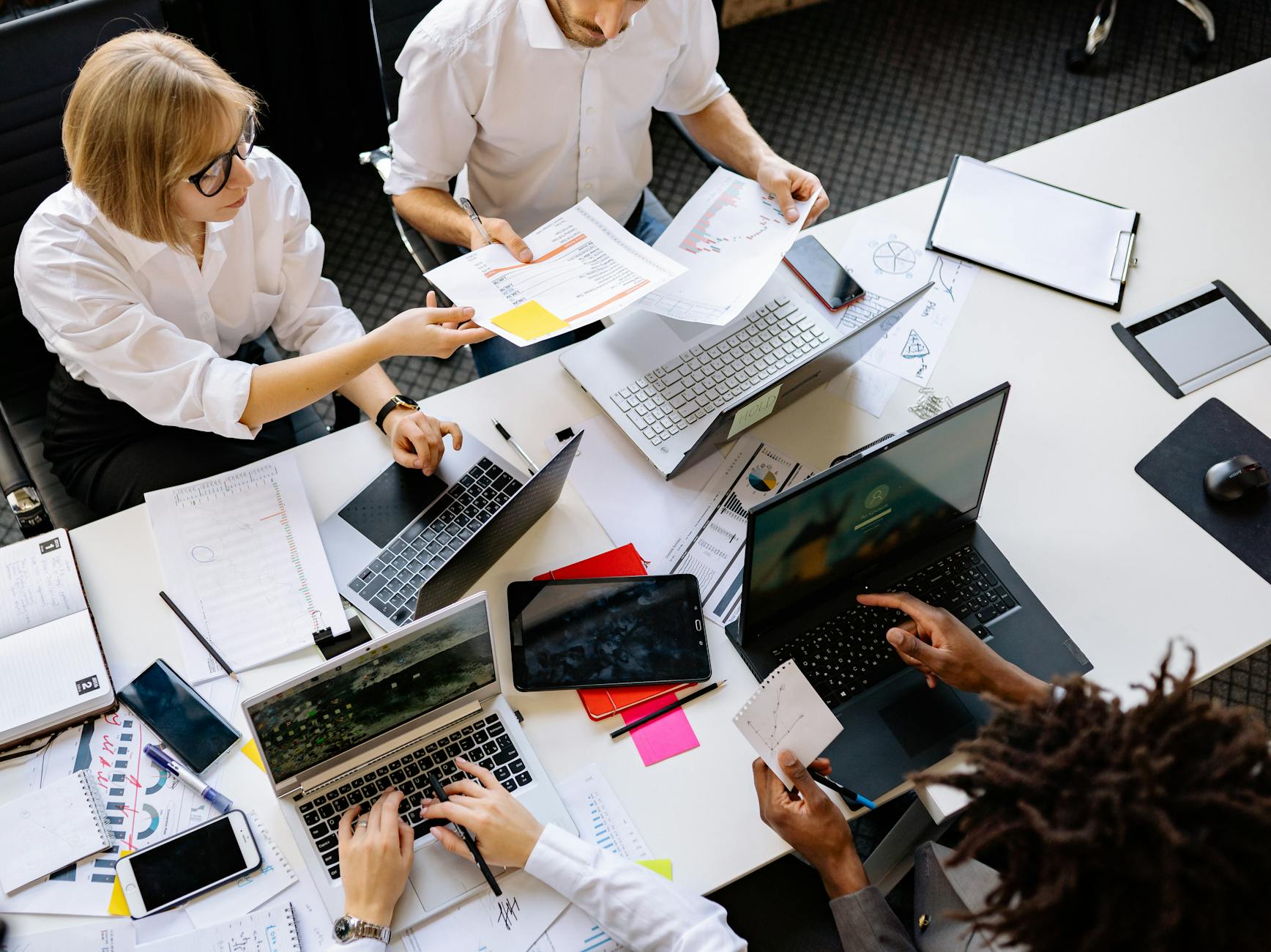 Two developers collaborating at laptops in a bright office, representing shared documentation accessible to multiple AI tools