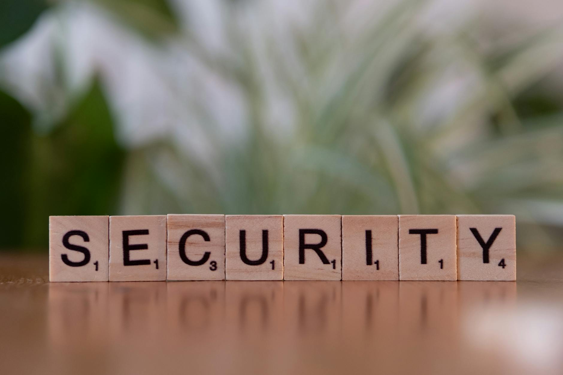 Wooden letter tiles spelling the word SECURITY on a surface with soft-focus background